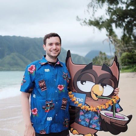 Greg with Owlbert on a beach.